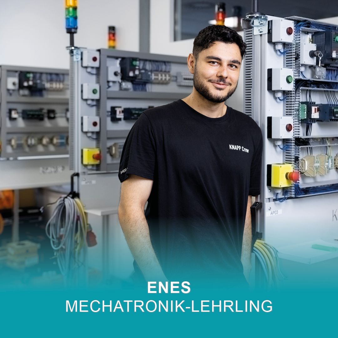 Mechatronik-Lehrling Enes steht lächelnd neben Schaltschränken in der Lehrwerkstatt