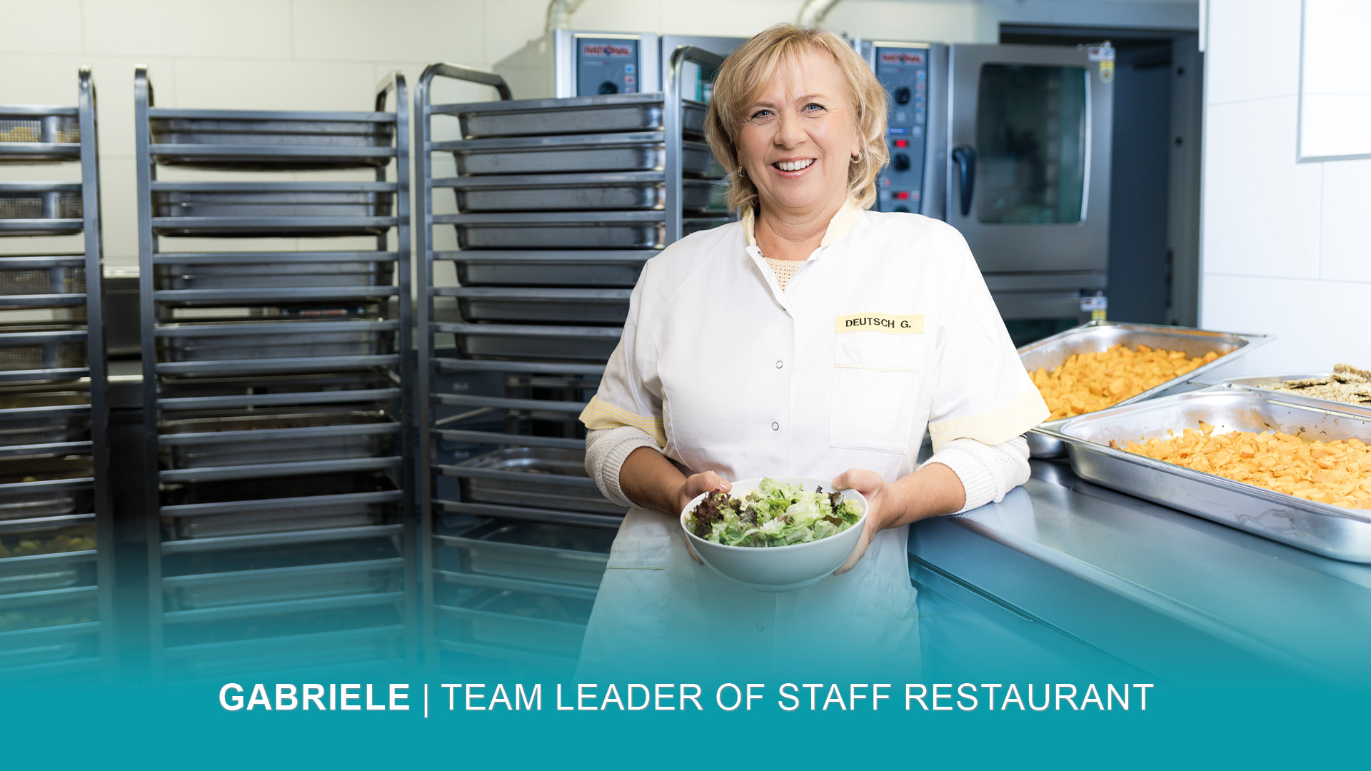 Gabriele tient une assiette de salade fraîche au restaurant de l'usine