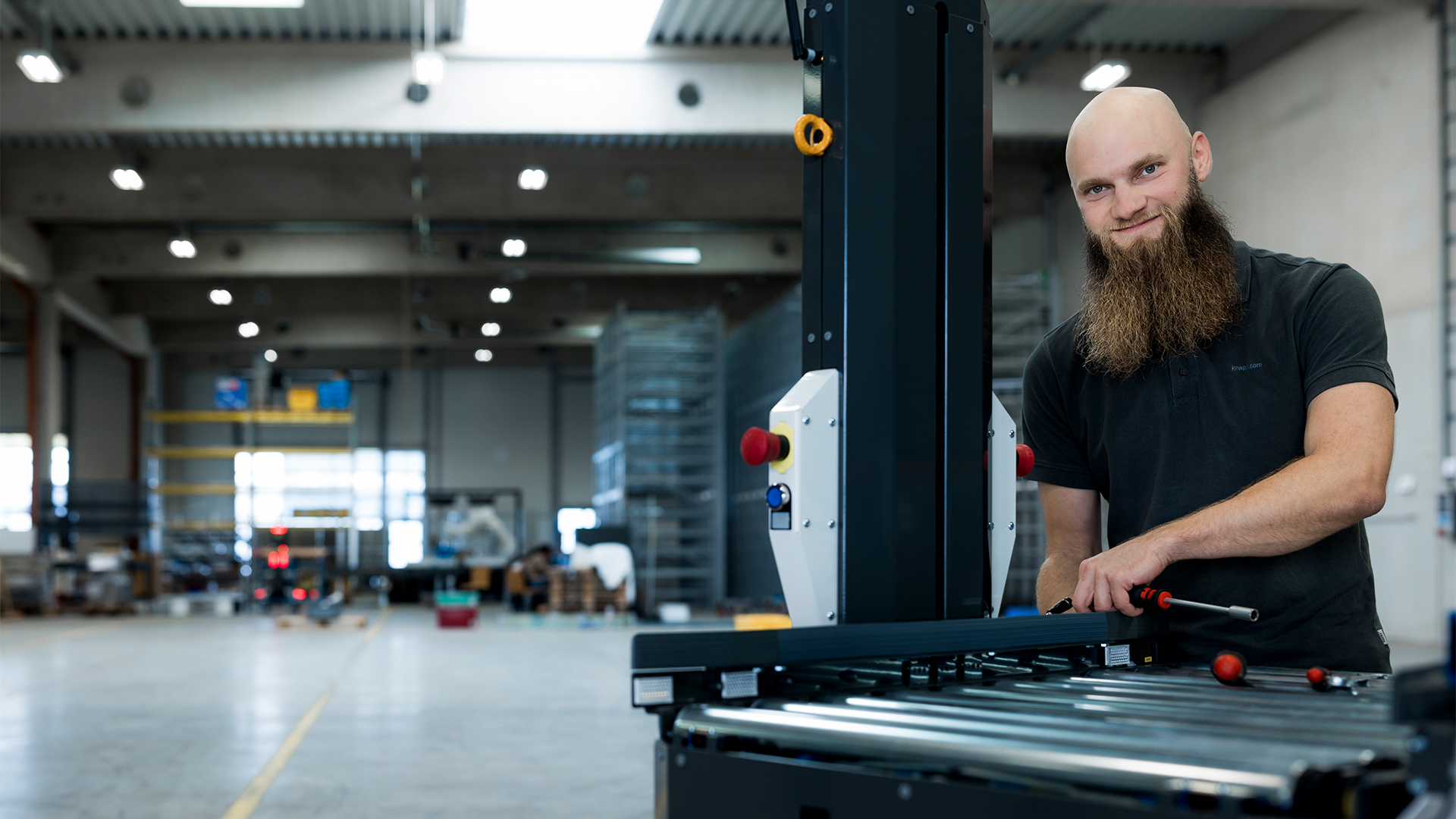 Georg arbeitet an einem Open Shuttle und lächelt freundlich in die Kamera