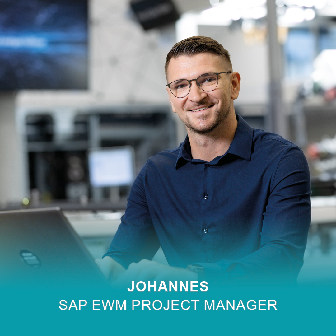 SAP EWM Project Manager Johannes sitzt arbeitend vor seinem Laptop und lächelt